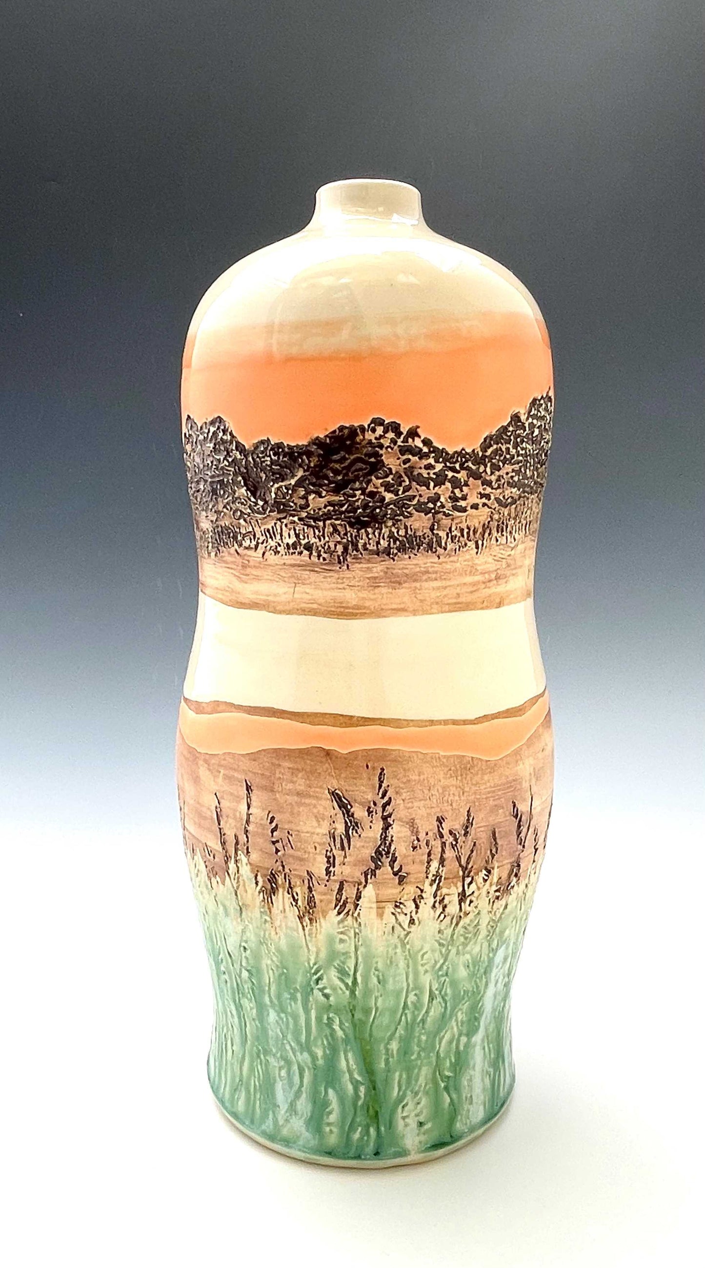 Tall wheel-thrown porcelain vase with coral, brown, white and light green glazes and a textured surface, representing a river sunset scene