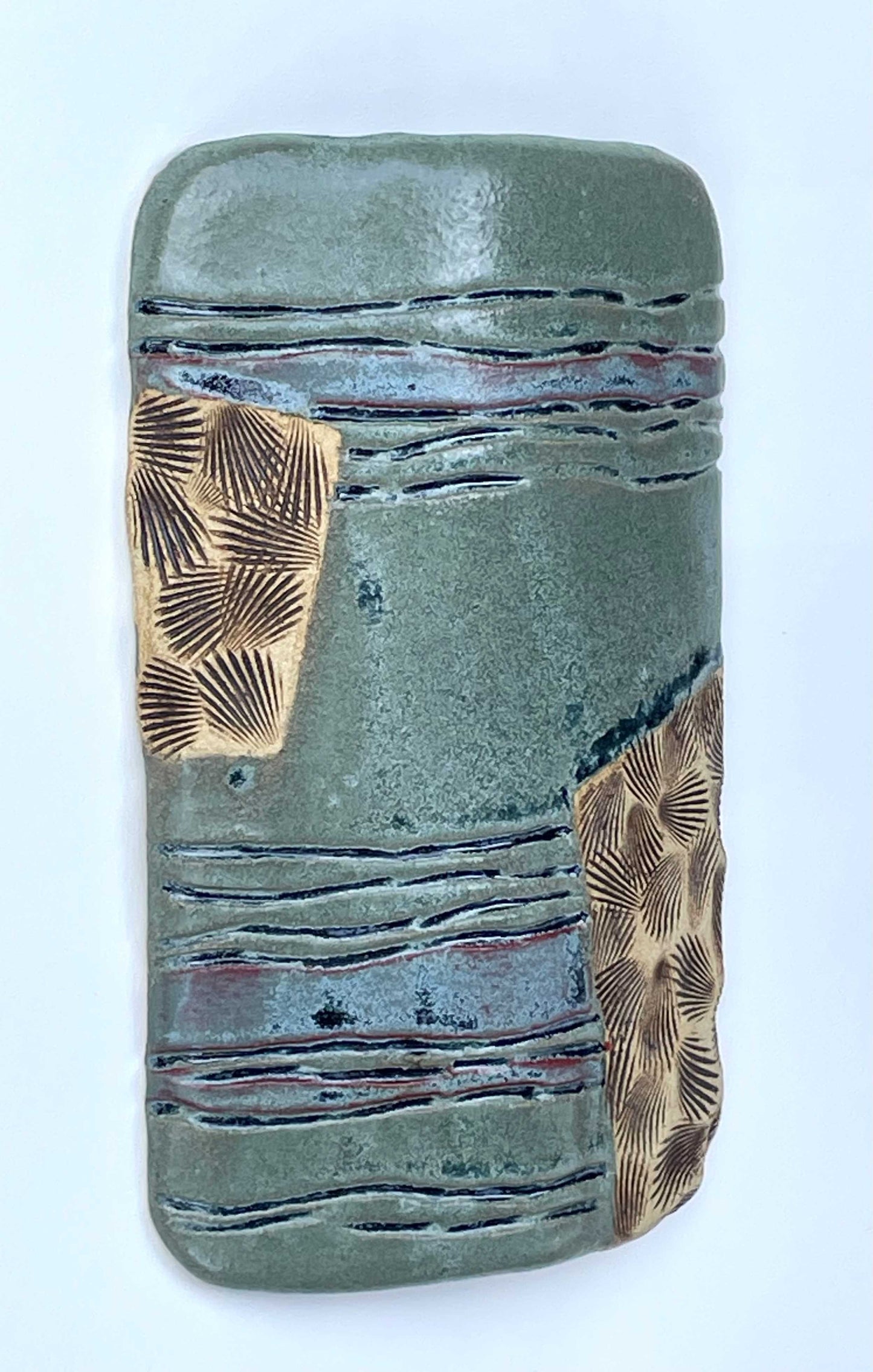 Ceramic tile with textured surface and shell patterns with green, blue and tan color glazes