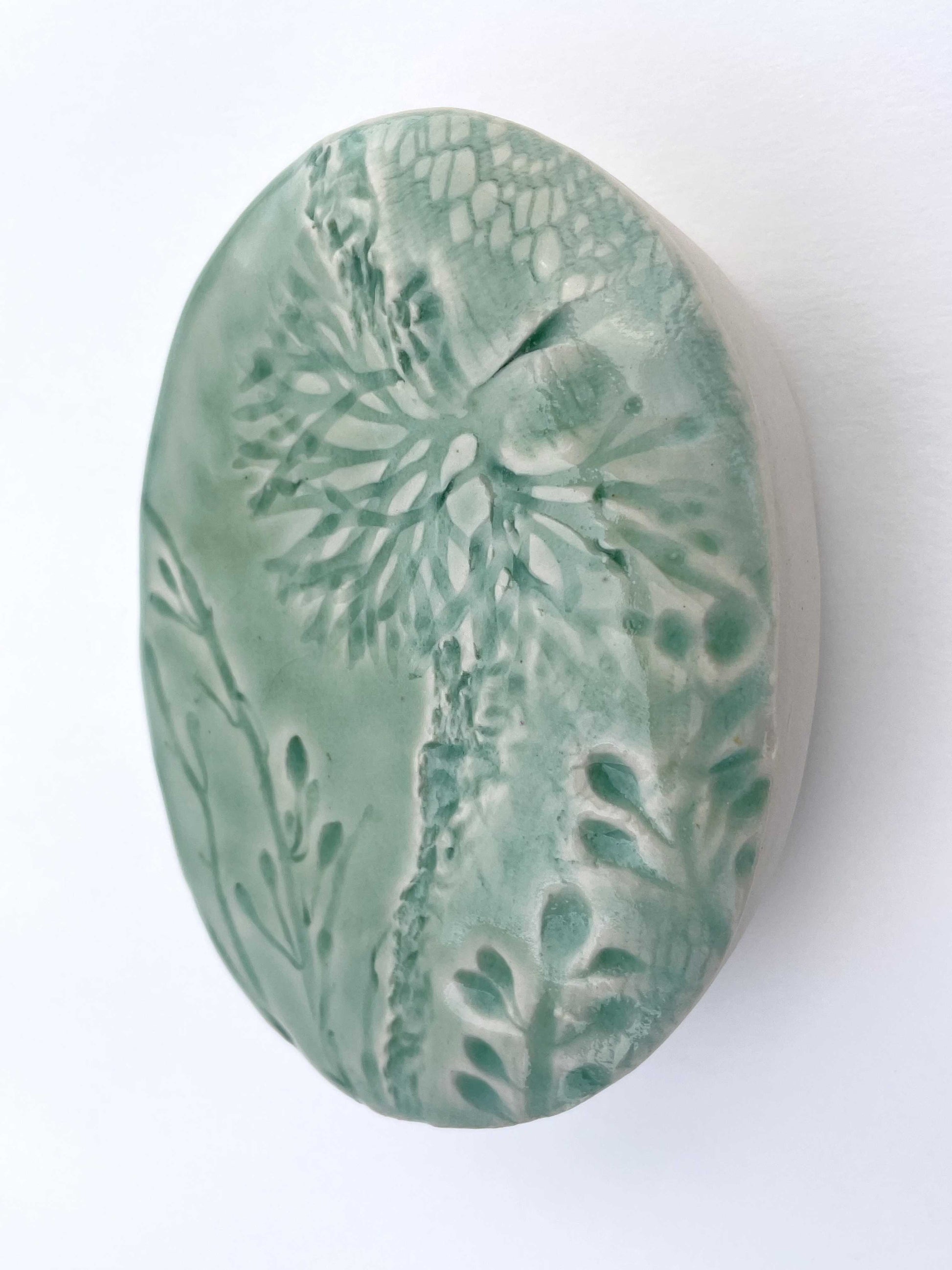 light green porcelain wall-hung sculpture with seaweed design