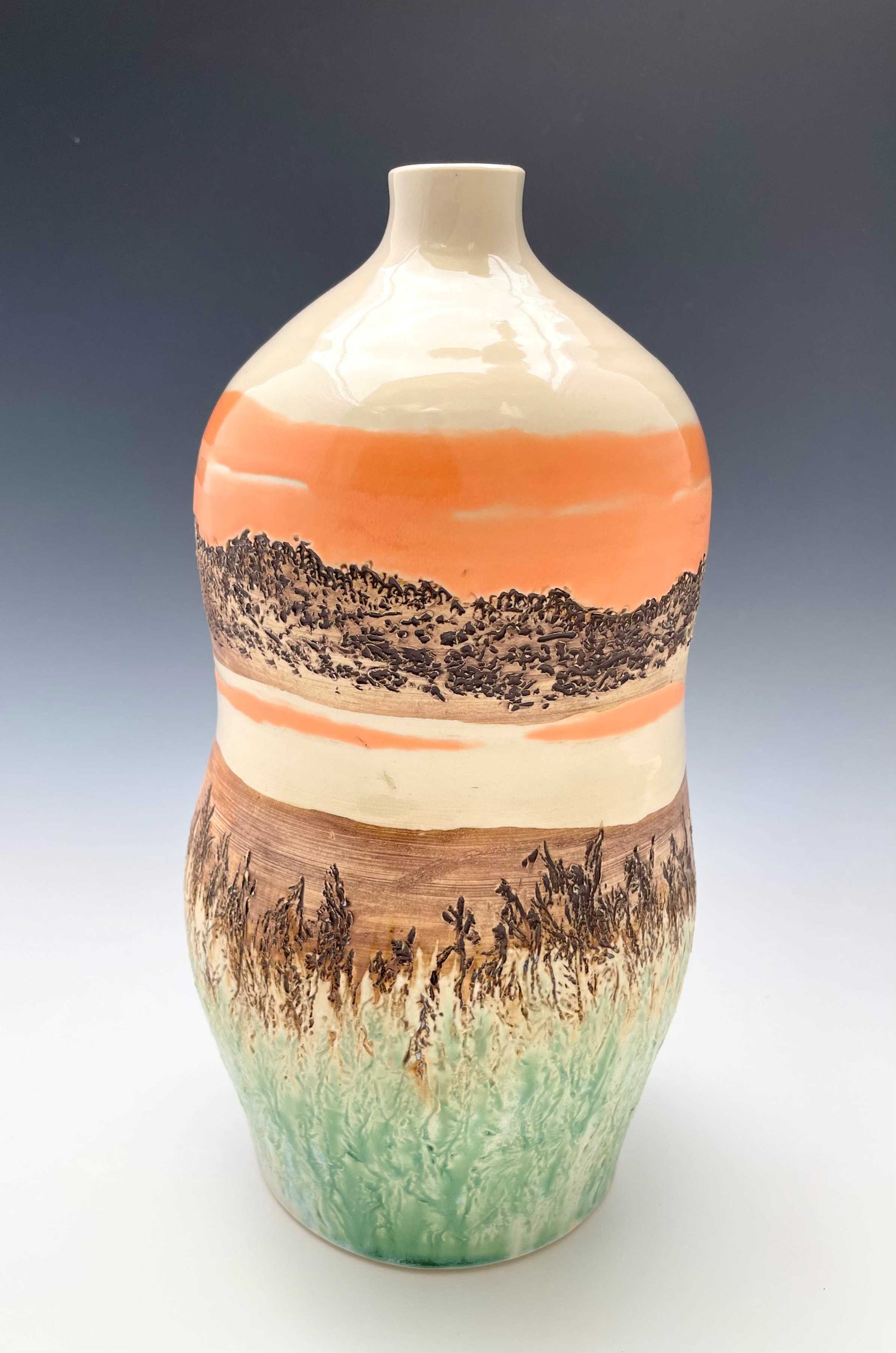 Tall wheel-thrown porcelain vase with coral, brown, white and light green glazes and a textured surface, representing a river sunset scene