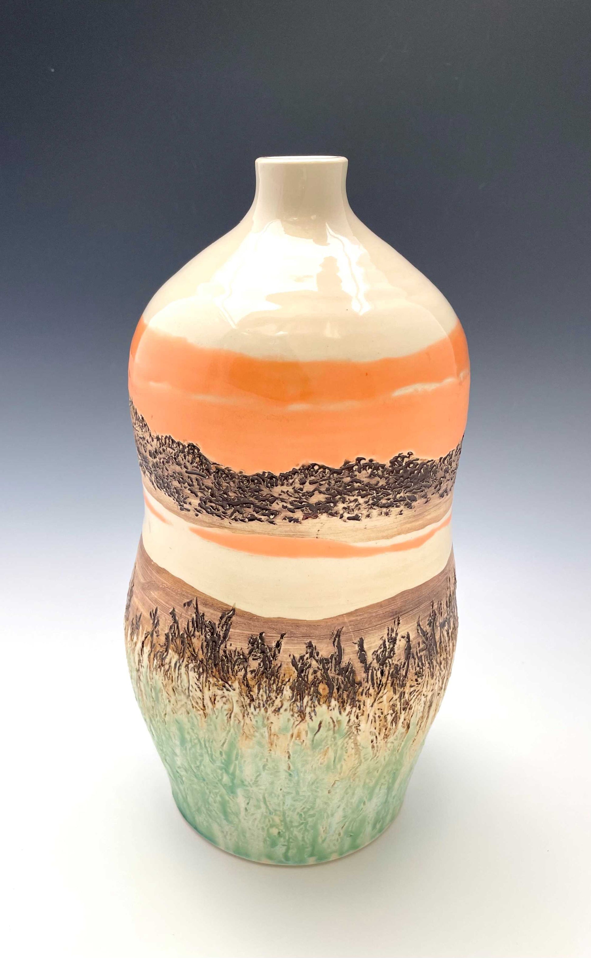Tall wheel-thrown porcelain vase with coral, brown, white and light green glazes and a textured surface, representing a river sunset scene