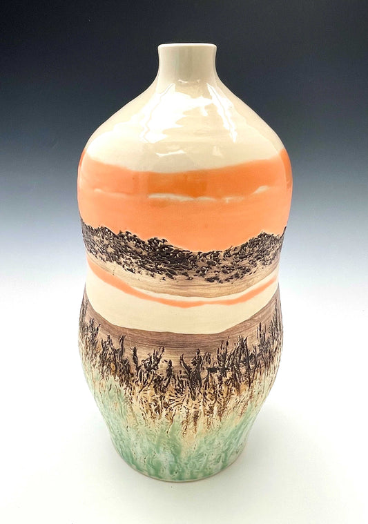 Tall wheel-thrown porcelain vase with coral, brown, white and light green glazes and a textured surface, representing a river sunset scene