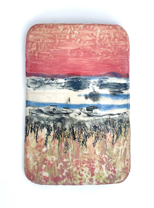 Rectangular porcelain wall-hung sculptural tile with coral, blue, white, grey and green glazes on a textured surface, representing an abstract sunset landscape scene