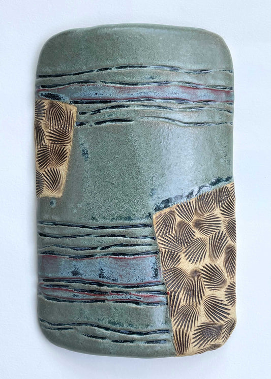 Ceramic tile with textured surface and shell patterns with green, blue and tan color glazes