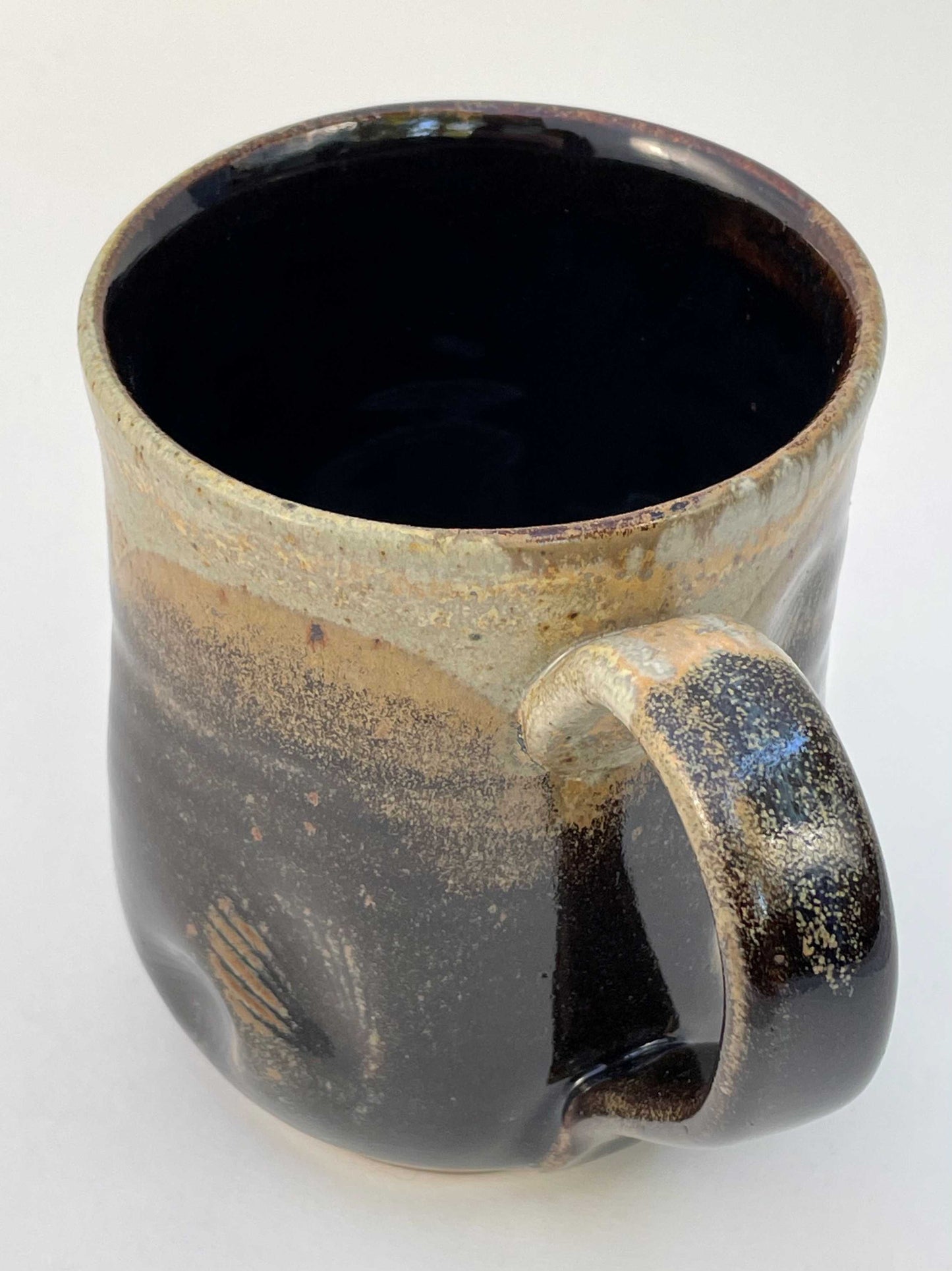 Ceramic mug with shell imprints and brown, orange and tan glazes