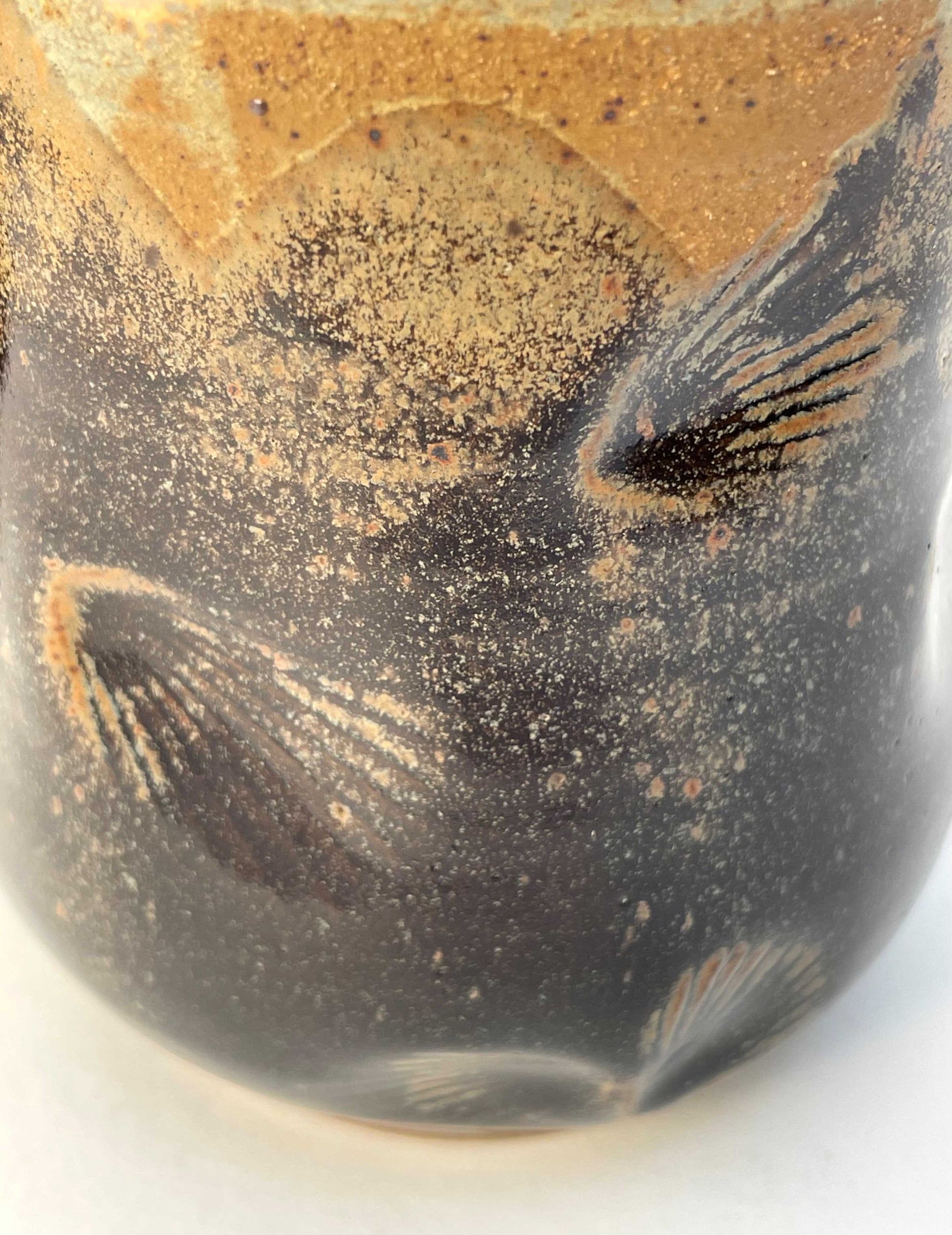 Ceramic mug with shell imprints and brown, orange and tan glazes