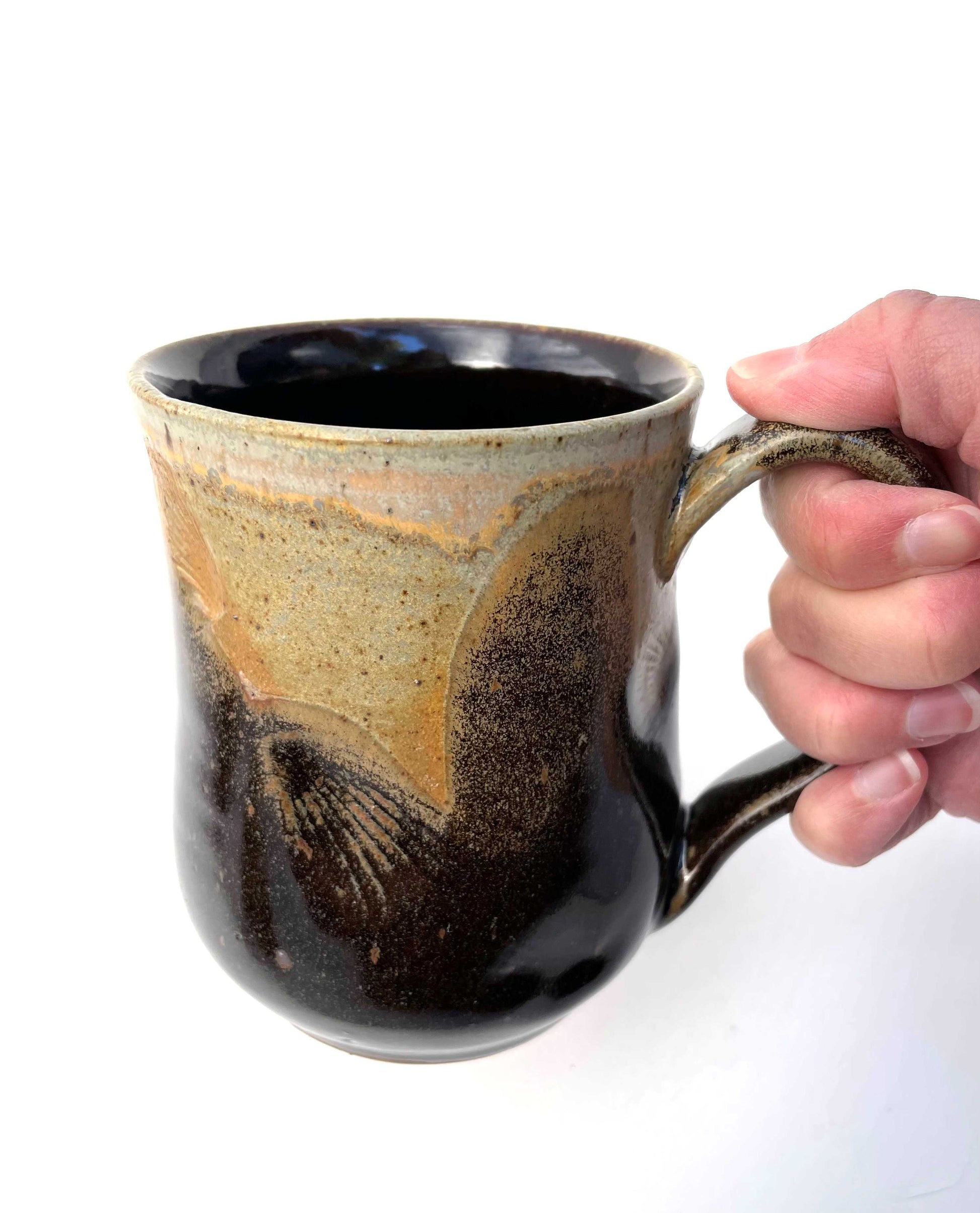 Ceramic mug with shell imprints and brown, orange and tan glazes