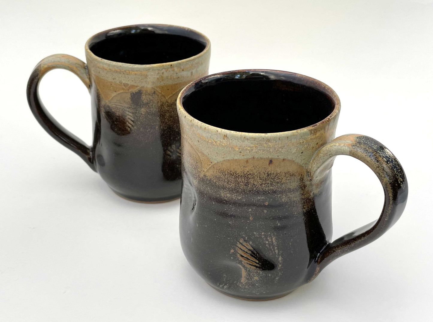 Pair of ceramic mugs with shell imprints and brown, orange and tan glazes