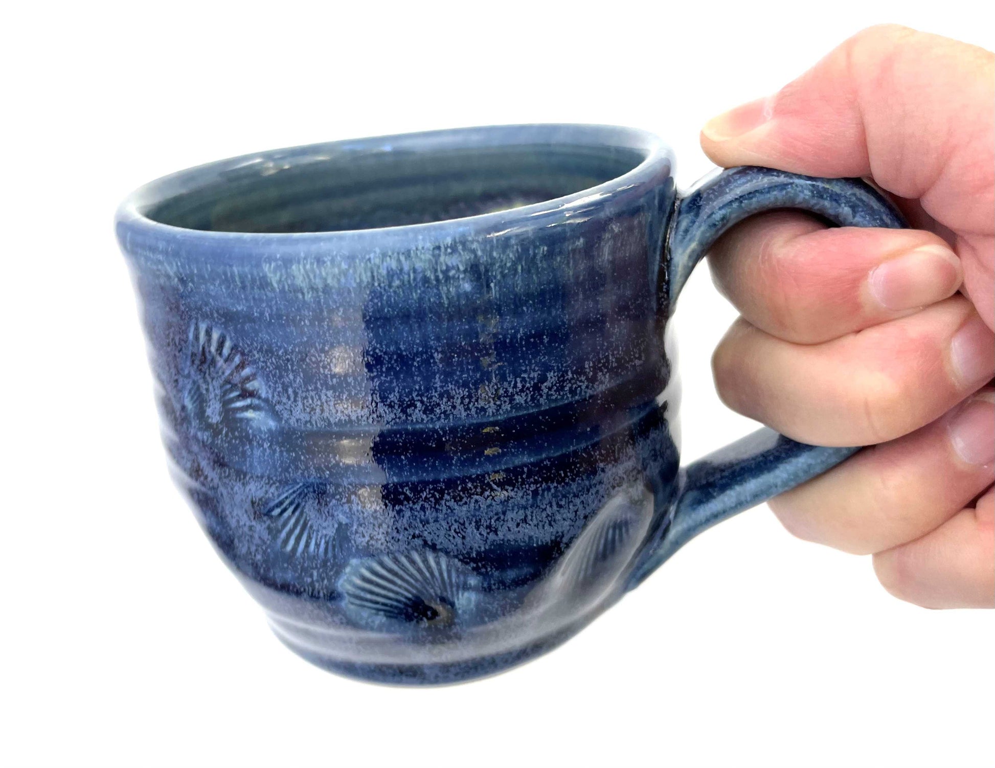 Blue ceramic mug with a textured surface and a yellow glazed interior