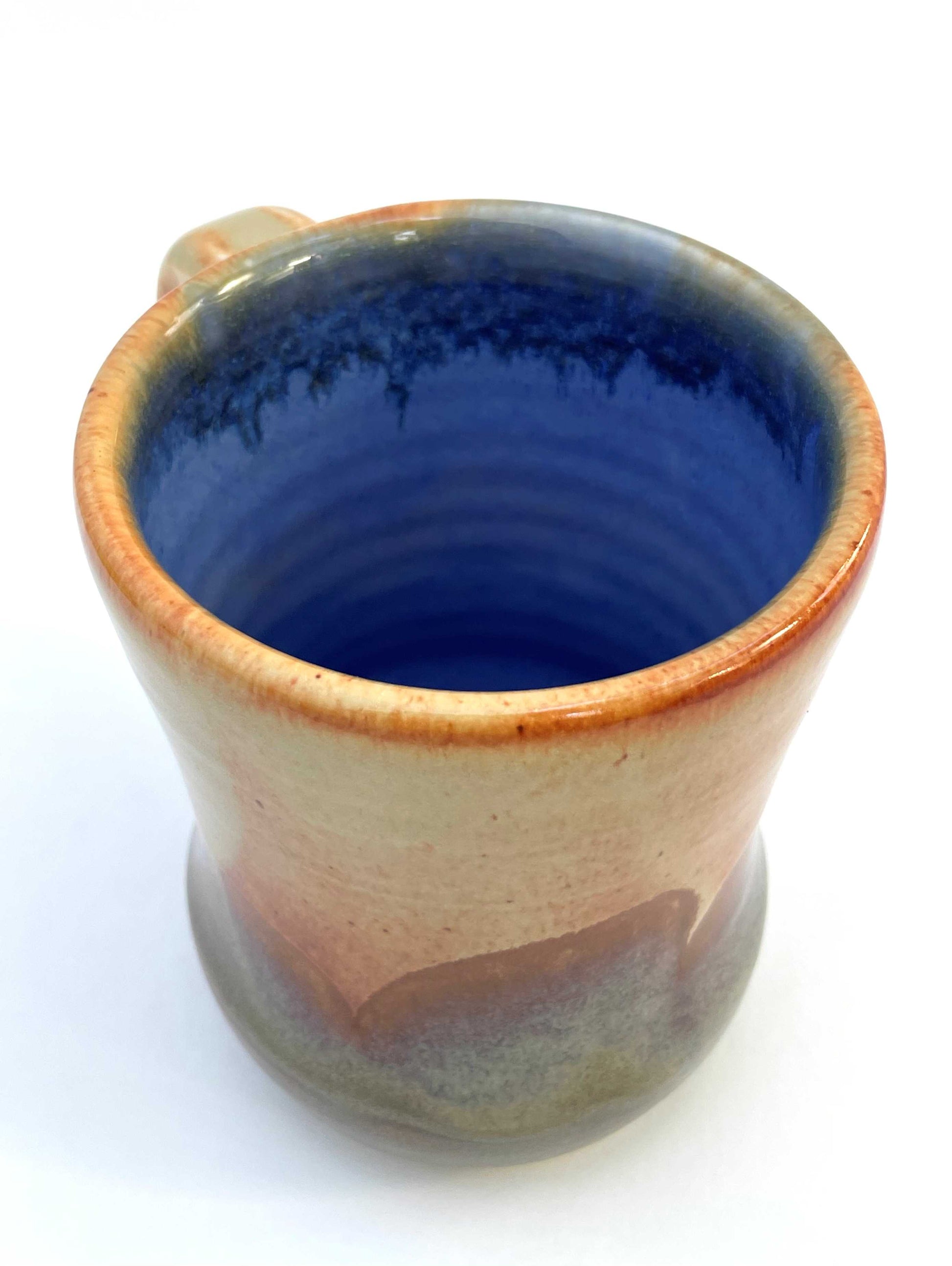 Ceramic mug with a blue interior, and orange, purple and green exterior
