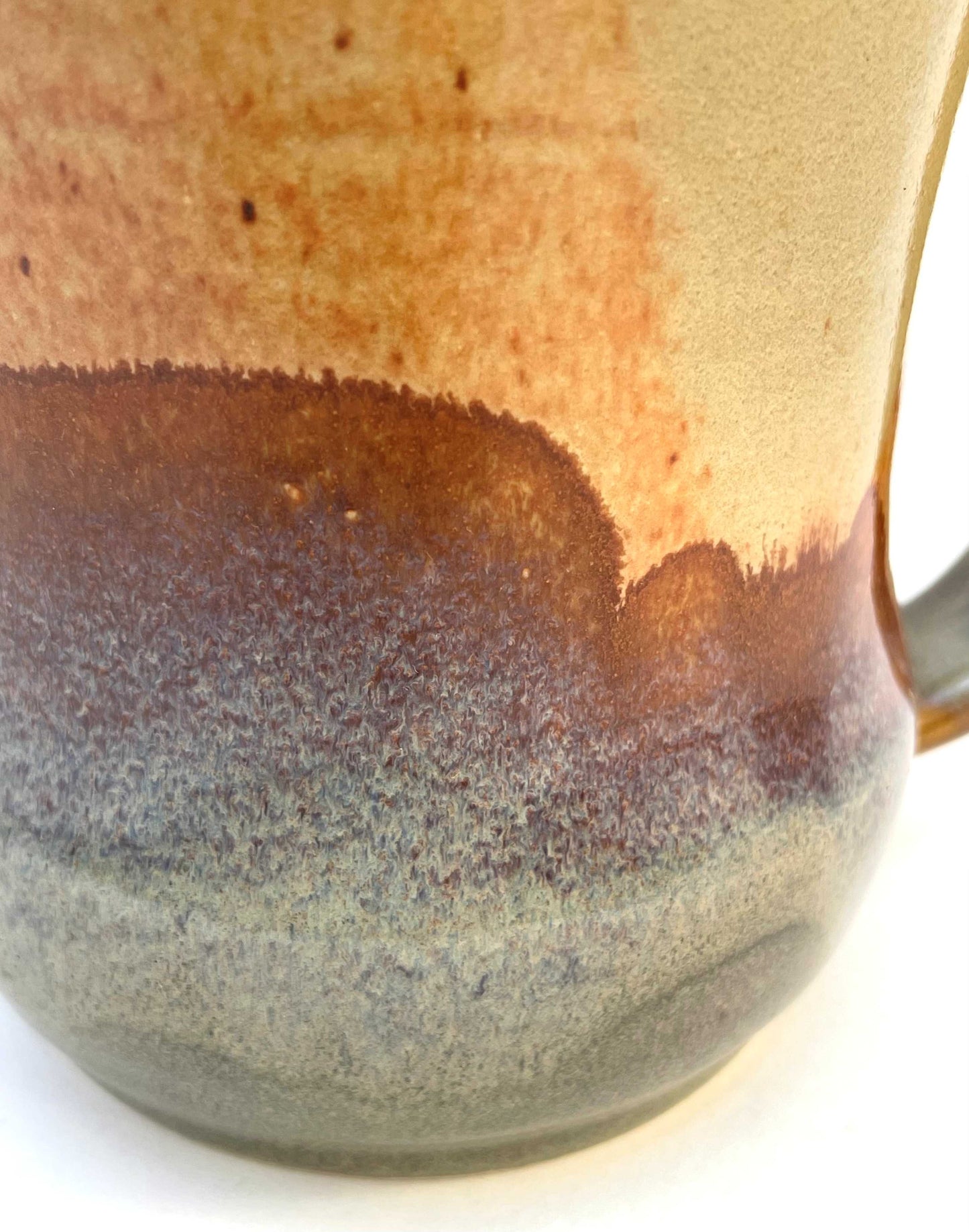 Ceramic mug with a blue interior, and orange, purple and green exterior